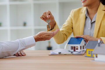 Estate business agent giving house keys to client after signing agreement contract real estate with...