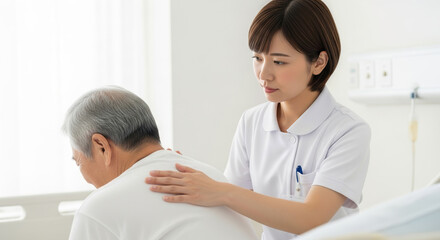患者の背中をさするアジア人看護師