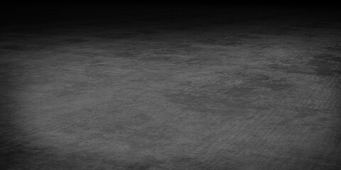 Dark textured concrete surface with subtle lighting effects.