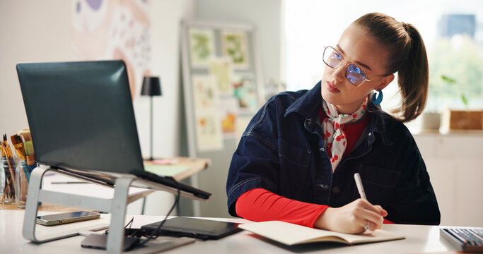 Laptop, woman and writing with notebook for graphic design, planning or idea inspiration. Freelancer, remote work and creative person with schedule for project draft, reminder and diary in home - Powered by Adobe