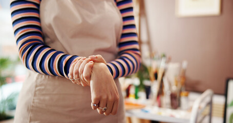 Hands, wrist pain and woman in studio, painter and carpal tunnel with inflammation. Closeup, home...