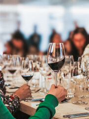 Wine tasting event: person holding a glass of red wine
