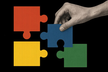 Hand placing puzzle piece.