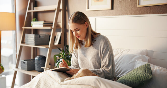 Happy woman, relax and writer with book in bed for morning inspiration, idea or journal in home. Female person, journalist or copywriter taking notes in bedroom for story, novel or reminder in house