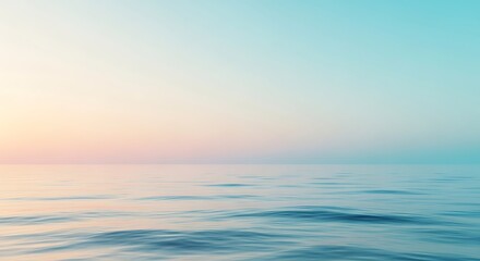 Obraz premium Calm ocean water with small waves under a gradient sky transitioning from light pink to soft blue.