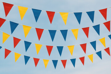 Fototapeta premium Colorful buntings fluttering against a blue sky.