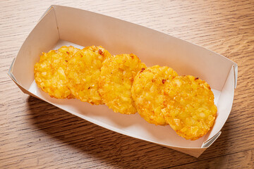 Savory potato patties, perfectly golden and crispy, await enjoyment in a minimalist tray