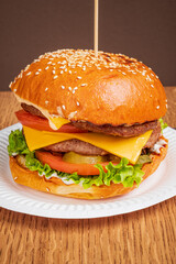 A tasty cheeseburger with fresh lettuce, tomato, pickles, and a grilled patty