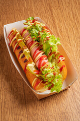 Two gourmet hot dogs on a stylish tray, topped with crisp lettuce and vibrant sauces
