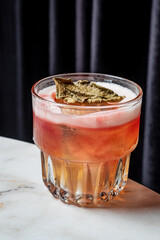 A vibrant cocktail with a striking garnish presented in an elegant glass at a trendy bar