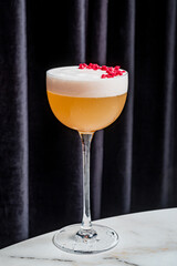 A gorgeous cocktail on a marble table, adorned with vibrant berries and rich textures