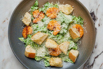 Bright green lettuce, grilled shrimp, and cheesy croutons create a fresh and inviting salad
