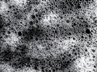 White soap foam texture isolated on black background. Shampoo foam with abstract shampoo gel foam bubbles. Contrast view of soap foam bubbles. Demonstrates cleanliness and hygiene.