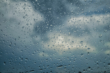 Raindrops on the window on a rainy day. View from the house. Nature background concept.