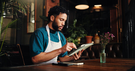 Waiter, man and typing on tablet in cafe for stock order, email supplier and inventory management. Small business, manager and digital app in restaurant for menu planning and check sales performance