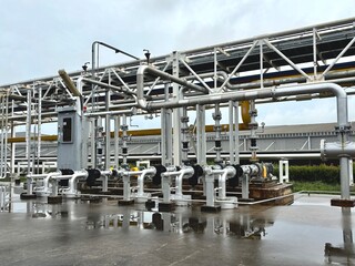 industrial zone steel pipes. Industrial electric motor pumps installed outdoors with connected pipelines and valves, used in cooling systems, HVAC, and fluid transfer operations in factories or energy