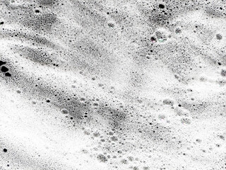 Abstract shape of white cleansing washing soap foam on dark backdrop. Soap water background. Clean foam abstract. Demonstrates cleanliness and hygiene.