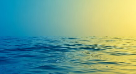 Obraz premium Calm ocean water with gentle waves under a gradient sky transitioning from blue to yellow, creating a serene and peaceful seascape.