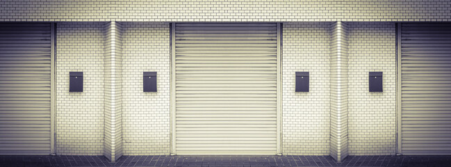 Closed steel shutter doors of warehouse, storage or storefront for retro vintage metal door background banner template.