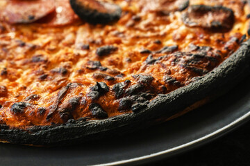 Burnt pizza. Pizza fail on a plate. Cooking fails.