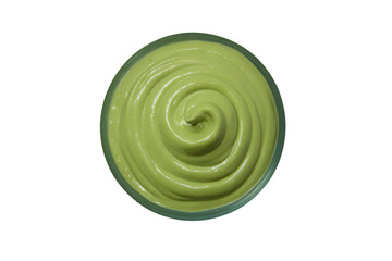a bowl of green cream on a white surface