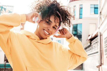 Beautiful woman with afro curls hairstyle.Smiling model in yellow hoodie.Sexy carefree female...