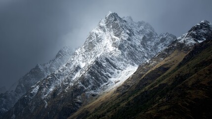 Snowy mountain peak piercing a cloudy sky