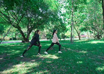 Asian woman in sportswear stretching and warming up before morning jogging. Sports training, jogging in city park.
