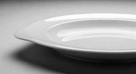 Elegant White Ceramic Plate with Smooth Curves and Glossy Finish for Modern Tableware and Stylish Dining Presentation in High-Quality Stock Image Collection