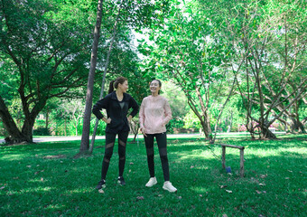 Asian woman in sportswear stretching and warming up before morning jogging. Sports training, jogging in city park.