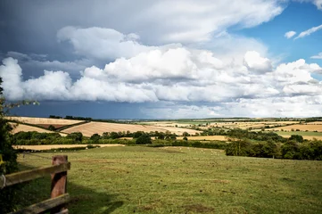 farmland scene with patchy fields under dramatic clouds. High quality photo © Tatjana