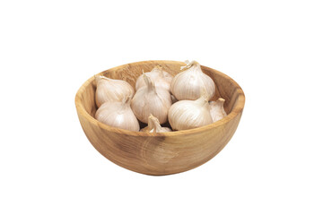 a wooden bowl filled with garlic on top of a white surface