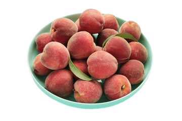 Sweet peaches and leaves on plate isolated on white background