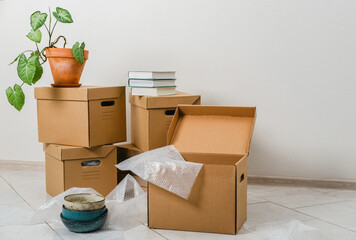 Cardboard boxes packed with personal belongings for moving. Relocating. Stack of cardboard box on floor. Pack personal stuff from carton boxes. 