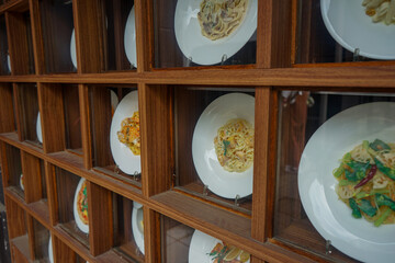Closeup view of Japanese food models, called shokuhin sampuru, in a window display outside a restaurant in Nara, Japan showing different pasta dishes
