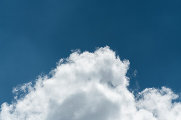 Background of a deep blue summer sky and fluffy white clouds