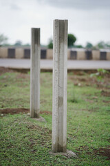Cement boundary pillars,Two standing cement posts,
Vertical concrete columns,Pillars near rural road,Concrete poles in open field,Construction site boundary poles stock photo.





