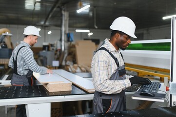 Furniture factory workers using cnc machine for sofa production