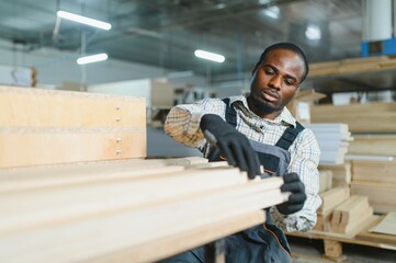 African american Carpenter working with wood in furniture factory
