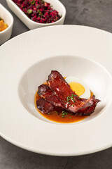 Barbecue pork slices with hard-boiled egg in a savory brown sauce