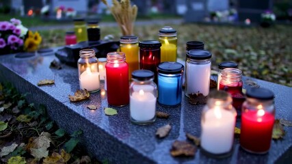 Solemn Remembrance: Colorful Candles Illuminate Tombstone in Cemetery for All Souls Day
