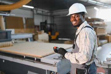 Furniture maker operating cnc machine in a factory