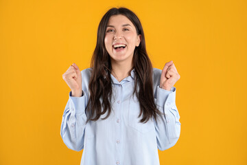 Portrait of surprised woman on orange background