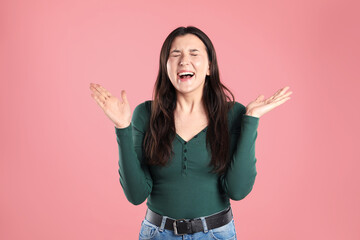 Portrait of surprised woman on pink background