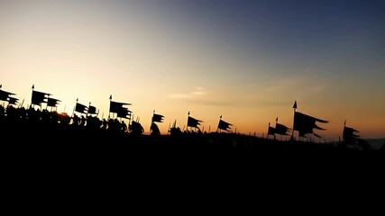 Silhouetted medieval army with flags marching on a hill during a dramatic sunset preparing for an ancient battle - Powered by Adobe
