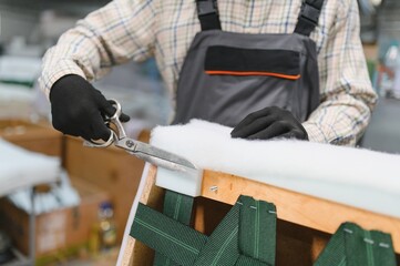 African american Skilled worker cutting fabric in sofa production process