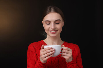 Smiling woman with cup of coffee on brown gradient background