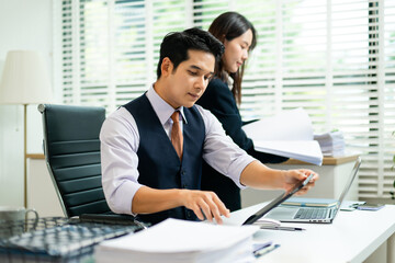 Confident business team in office attire reviewing documents and tablet, showcasing teamwork,...
