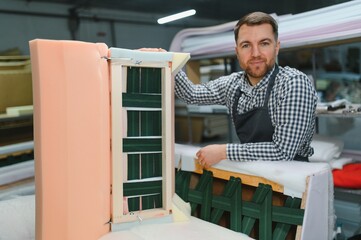 Carpenter building sofa frame in furniture workshop