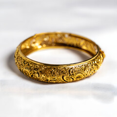 A gold bracelet with a design on it